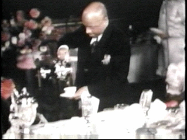 FATHER DIVINE serving hot drinks at the Holy Communion Table, Rockland Palace, N.Y.C..